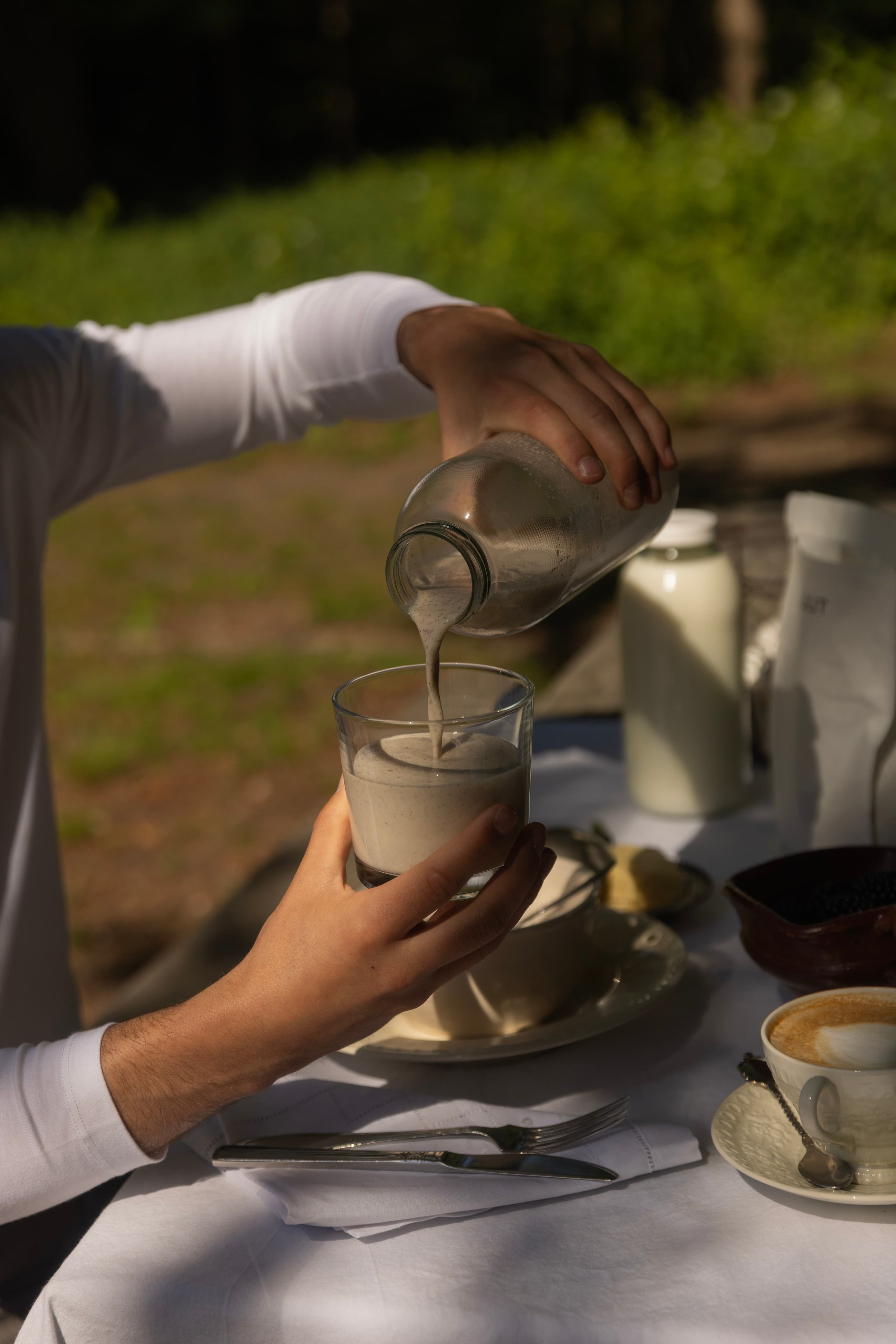 Preparing ZUUT organic grass-fed whey protein shake with milk outdoors